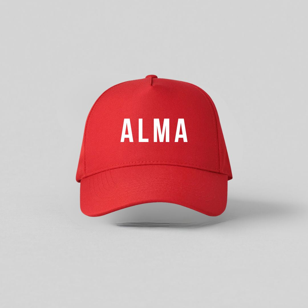 Rød børnekasket med hvidt navnetryk Alma set forfra