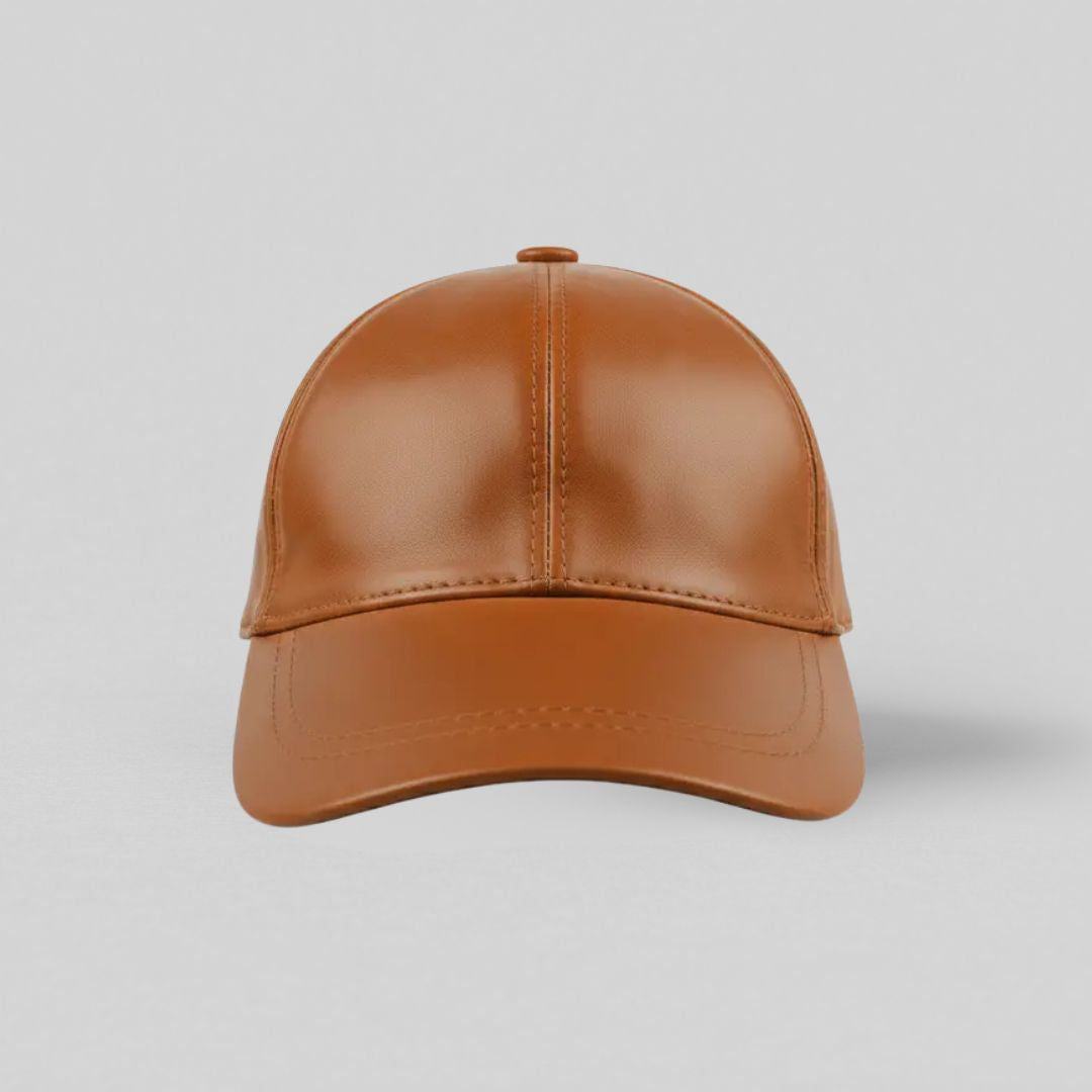 Brun læderkasket til herrer i klassisk 6-panel model med forbøjet skygge og velcrolukning — set forfra mod grå baggrund.
