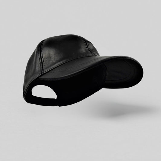 Sort læderkasket til herrer i klassisk 6-panel model med forbøjet skygge og velcrolukning — set forfra mod grå baggrund.